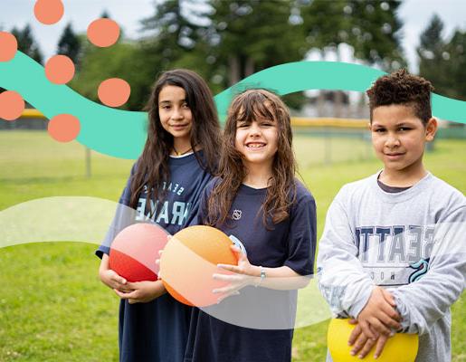 一群孩子穿着西雅图克拉肯牌的衣服，手里拿着色彩鲜艳的球